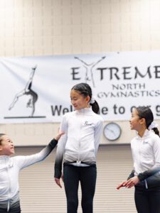 thrive gymnastics aurora ontario three gymnasts teamwork at invitational